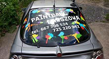 Paintball Ławszkowa - Opel Tigra. Na tylnej szybie zostały naklejone napisy wycięte z folii samoprzylepnej oraz kształty opodobnione do śladów zostawianych przez kulki z farbą.